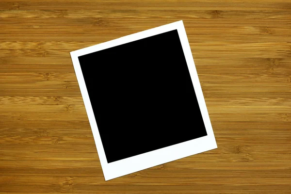 Blank photo frame on wooden background — Stock Photo, Image