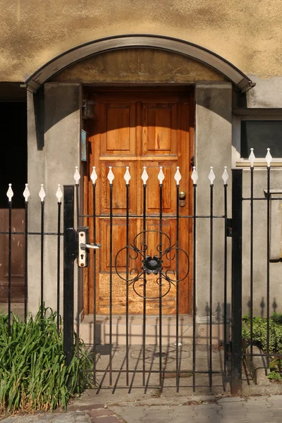 Porta de madeira e portão forjado — Fotografia de Stock