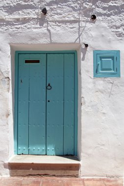 Mavi ahşap kapı ve badanalı duvar