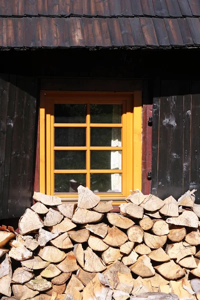 Topos de árboles bajo ventana de cabaña de madera —  Fotos de Stock