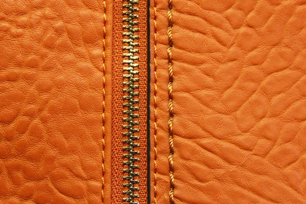 Skóra Orange tło z zamkiem błyskawicznym — Zdjęcie stockowe