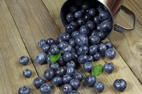 Blueberries in metal cup on wooden background — Stock Photo, Image