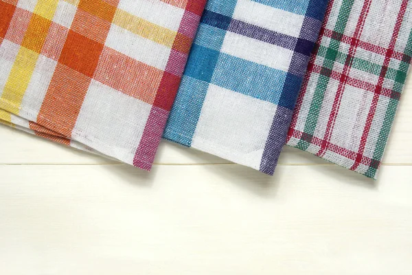 Coloridas toallas de plato sobre mesa de madera blanca —  Fotos de Stock