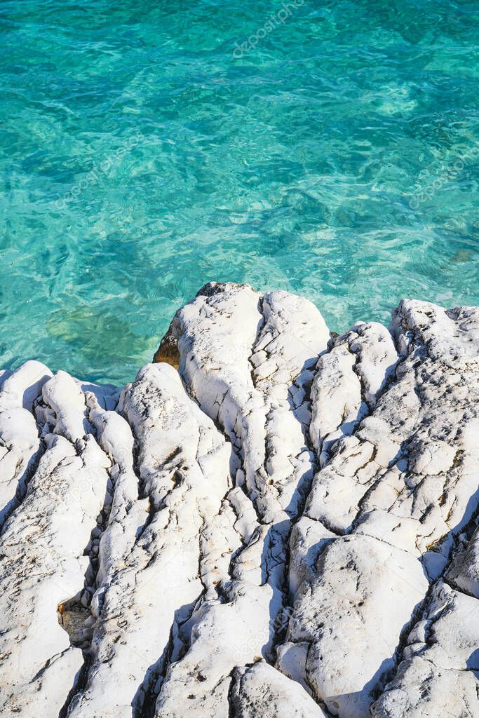 turquoise sea waves and stone coastline on the Kanoni Beach, Kassiopi, Corfu island, Greece   