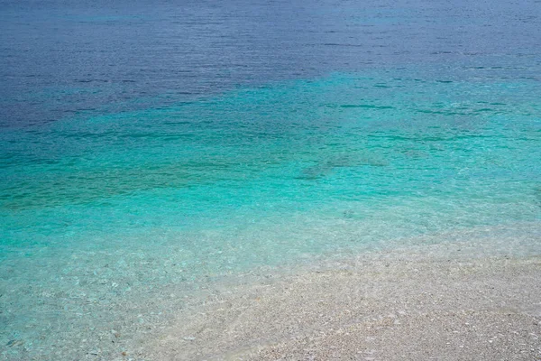 穏やかなターコイズブルーの海と小石のビーチ — ストック写真