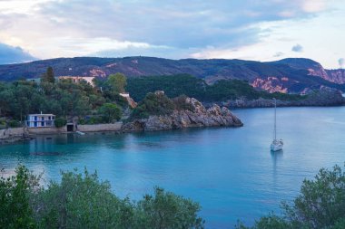 Güzel turistik köy Paleokastritsa 'nın kayalık kıyıları, Corfu Adası, Yunanistan gün batımında