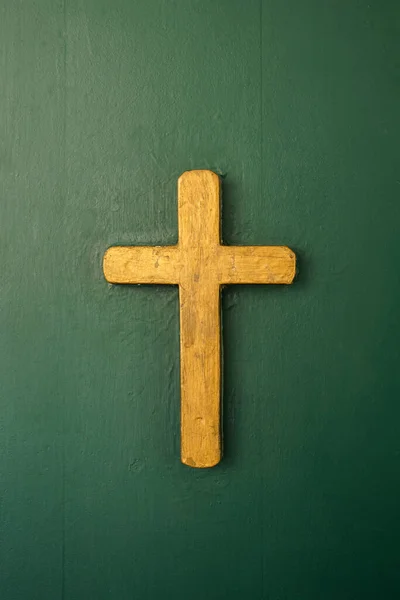 緑の木製のドアに黄金のカトリックの十字架 — ストック写真