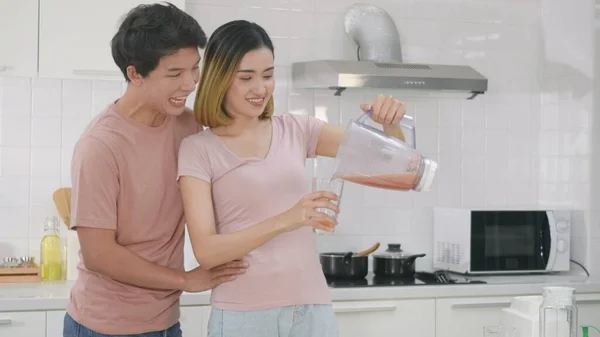 아시아 의젊은 부부와 부엌에서 스무디 즐기고 여자는 남자가 마시도록 믹서에서 — 스톡 사진
