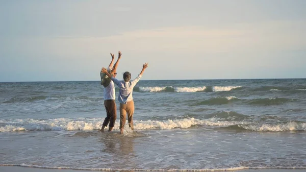 아시아의 활동적 해변으로 달려가 즐겁고 낭만적 노인들은 방학을 즐기고 부부에게 — 스톡 사진