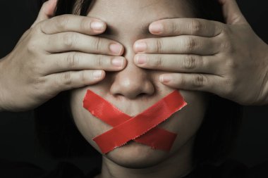 Asyalı bir kadın siyah arka planda kırmızı bantla gözlerini bağlıyor. Konuşma özgürlüğü sansürü ve konuşmayı durdurmak, Uluslararası İnsan Hakları Günü