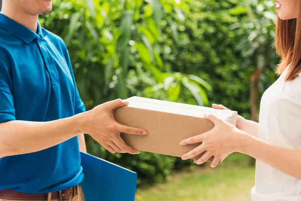 Üniformalı genç teslimatçı kurye paket posta kutuları servis sevkiyatı kadın müşteri teslimat paketini ön evden, çevrimiçi alışveriş hizmeti konseptlerinden kabul ediyor