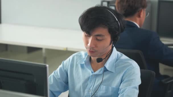 呼叫中心年轻员工与耳机合作 微笑客户支持操作员团队在工作中被同事围绕 服务台客户服务支持代理的概念 — 图库视频影像