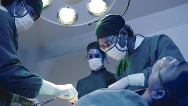 手術を行う医療外科医チーム 病院の心血管緊急手術センターの電気治療装置を備えた手術室で働くグループ外科医 — ストック動画