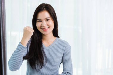 Asya portresi mutlu güzel bir kadın gülümseyen güzel bir yüz uzun saçlı başarılı olun ya da kazanan bir jest yapın. Stüdyo çekimlerinde evde kameraya bakın ve mesajınız için bir kopya alanı olsun.