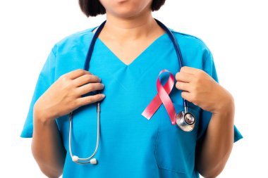 Stüdyoda göğsünde kırmızı kurdele bulunan HIV AIDS farkındalığını destekleyen klinik üniformalı kadın hemşire beyaz arka plan, sağlık ve tıp, Dünya AIDS Günü konsepti üzerine izole edilmiş.