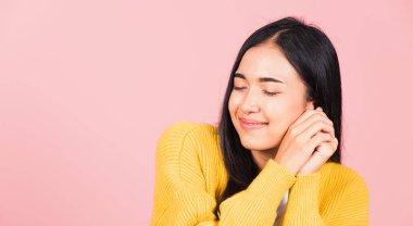 Mutlu Asyalı portre güzel sevimli genç neşeli melez kadın gülümse utangaç yüz ifadesi, stüdyo çekimi izole pembe arka plan, Taylandlı kadın utangaç zevk iki elini de yüze koy, kopyala boşluk