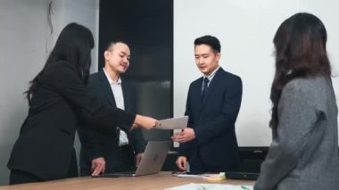 İş adamları birlikte çalışacaklarına ve iletişim kuracaklarına ve alkışlayacaklarına güveniyorlardı. Başarılarını alkışlıyorlardı. Ofisteki toplantı odasında mutlu ve gülümsüyorlardı.