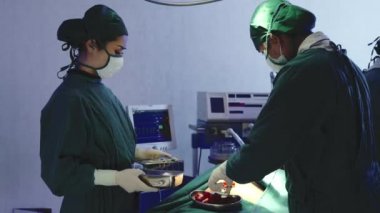 Tıbbi cerrahi doktor ekibi ameliyat yapıyor, grup cerrahı hastanede kardiyovasküler acil ameliyat merkezi için elektrokoterapi ekipmanıyla ameliyathanede çalışıyor.