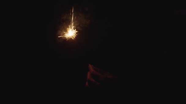 暗い夜に彼女の手の中に明るい火花火 幸せな新年のお祝いの輝き 抽象的なクリスマス花火の背景 冬のクリスマスの装飾 — ストック動画