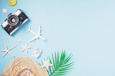 Düz açılı eski kamera filmleri, uçak, denizyıldızı, kabuk, şapka gezgini tropikal aksesuarları fotokopi alanı, iş gezisi ve tatil yaz seyahati konseptine sahip mavi arka planda yatıyordu.