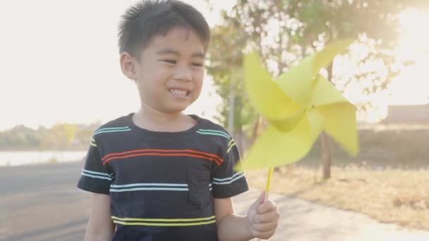 Asiatiska Barn Pojke Leker Med Pinwheels Lycka Liten Pojke Ler — Stockvideo