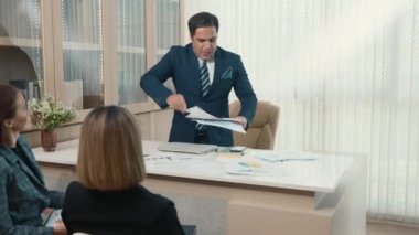 Kızgın kızgın patron yönetici anlaşmazlık içinde bağırıyor ve grup toplantısındaki çalışanla birlikte çalışma kağıtlarını masaya fırlatıyor, kızgın yönetici hedef iş planını başarısız yapıyor.