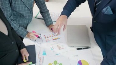 İş ekibi toplantısı, projenin sunumunu sunar. Ofiste gelir tabloları grafikleri, İş Analiz Stratejisi değerlendirme verileri, fikir sunumu ve finansal pazarlama stratejisinin karşılama stratejisi