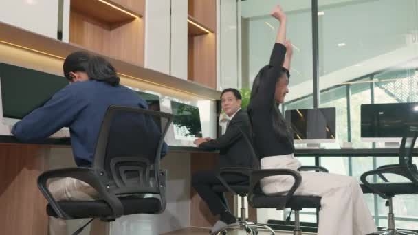 快乐的女商人兴奋地坐在椅子上 举手表决电脑屏幕 愉快地庆祝胜利 在办公室里成功地实现了项目 — 图库视频影像