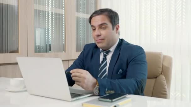 デスクの同僚とラップトップコンピュータのテレビ会議を使用して座っているビジネスマン オンラインビデオ会議に参加する幸せな男はオフィスでオンラインで働いている仮想会議リモートワークを呼び出します — ストック動画