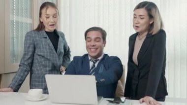 Bir grup genç iş adamı ofiste bir dizüstü bilgisayarla birlikte çalışıyorlar proje ekibi patronla konuşuyor bilgisayarla iş planını tartışmak için mutlu çalışma günleri.