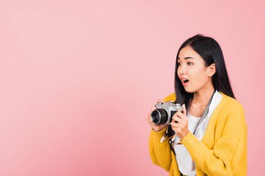 Çekici, mutlu bir Asyalı portresi hayat tarzı güzel bir kadın elinde eski moda fotoğraf makinesi olan gülümseyen bir fotoğrafçıyı heyecanlandırıyor pembe arka plan, turizm ve tatil konseptine izole edilmiş bir şekilde çekmeye hazır.