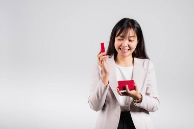 Gülümseyen kadın özgüveni, avuç içi izole edilmiş beyaz arka planda kırmızı bir hediye kutusu açıyor, sürpriz doğum günü veya Noel günü ve sevgililer günü, Asyalı mutlu portre güzel genç bayan stüdyo resmi, kopyalama alanı