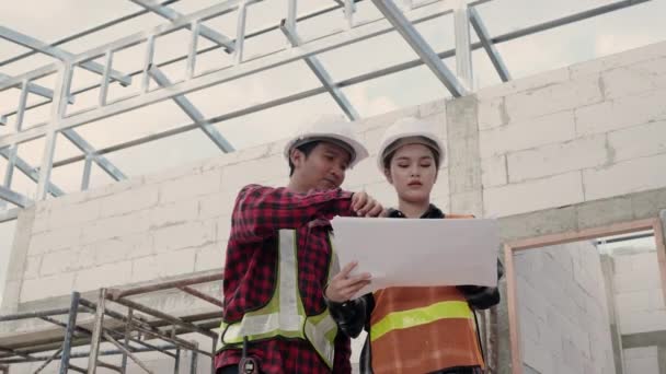 建設現場の建物の設計図と計画を議論する建築家とクライアント — ストック動画