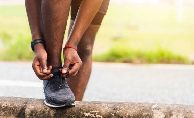 Kapatın Asyalı spor koşucusu, siyah adam saat takın, yaya yoluna çıkın, ayakkabı bağcığı deneyin, koşuya hazırlanın, açık hava sokak sağlık parkına koşun, sağlıklı egzersiz konsepti.
