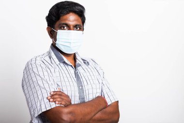 Koronavirüse karşı cerrahi hijyenik koruyucu yüz maskesi takan yakışıklı Asyalı yakışıklı bir adam ve çapraz kol duruşu, izole edilmiş beyaz arka plan, COVID-19 tıbbi konsept.