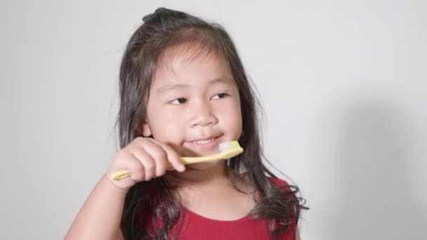 의귀엽고 귀여운 스튜디오에서 배경에 고립된 양치질을 미소짓습니다 칫솔을 아시아 아이들 — 비디오