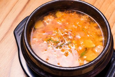 Kimchi çorbası sıcak, siyah tencerede, Kore geleneksel kimchi jjigae çorbası restoranda, Japon sıcak yemeği.
