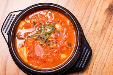 Kimchi çorbası sıcak, siyah tencerede, Kore geleneksel kimchi jjigae çorbası restoranda, Japon sıcak yemeği.