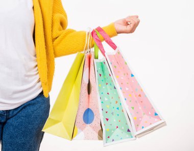 Mutlu kadın eli sarı gömlek giyiyor alışveriş poşetleri taşıyor, çok renkli, genç bayan beyaz arka planda izole edilmiş kollar içinde bir sürü paket tutuyor, Kara Cuma satış konsepti