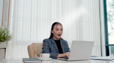 Mutlu iş kadını, beyaz ofis masasında sürpriz bir iş için heyecanlı. Bilgisayarından kağıt hesap dökümanları atıyor, kadın patron kağıtları fırlatıyor. Havada uçuyor.