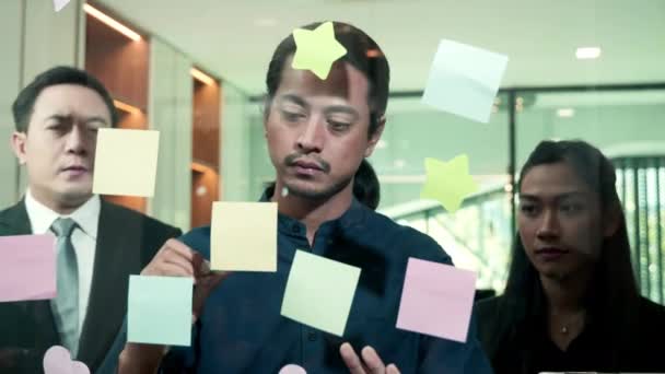 사무실에서 접착제 노트를 붙이고 창의적 아이디어에 도움을 팀워크는 개념에 종이에 — 비디오