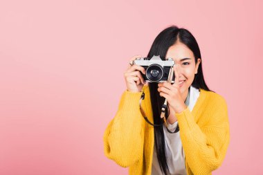 Gülümseyen fotoğrafçı kadın fotoğraf çekiyor ve manzaraya bakıyor.