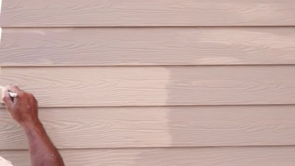 塗装ブラシ 改修や修理の建設で家の外にコーニスや成形外装上の木工茶色の色を塗装するビルダーの労働者 — ストック動画