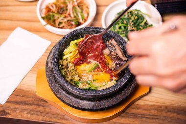 Bibimbap siyah ısıtılmış taş kasede, Kore geleneksel yemeği - bibibimbap sebze ile karışık pirinç sığır eti ve kızarmış yumurta, Japon sıcak tenceresi