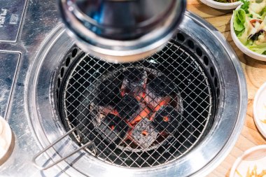 Kore barbekü sobası ve dumanlı başlık. Etleri ızgara yapmak için ızgara ve restoranda kömürle yakmak için aşağı