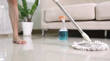 Asyalı bir kadın evde paspas ve bez parçasıyla yerleri yıkıyor, ev hanımı evinde yerleri paspaslıyor, evini temizliyor, profesyonel temizlik konsepti.