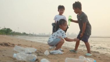 Gönüllü, mutlu aile çocukları plastik şişeyi plastik torbaya koyup plajı temizliyor, çocuklar gün batımında çöpleri temizliyor, ekoloji ve dünya çevresini kurtarıyor.