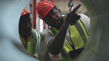 Metal levha fabrikası deposuna sevkiyattan önce iki mühendis Afrikalı siyah işaretli teftiş, fiziksel envanter sayımı, hisse senedi endüstrisini kontrol.