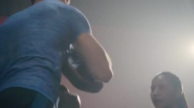 Asyalı güzel genç kadın boks eldivenlerinde antrenörle antrenör, savunma dersleri yumruk atma, erkek eğitmenlerle kadın kickboks eğitimi spor salonunda spor, sağlıklı spor konsepti.