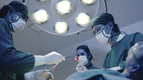 手術を行う医療外科医チーム 病院の心血管緊急手術センターの電気治療装置を備えた手術室で働くグループ外科医 — ストック動画